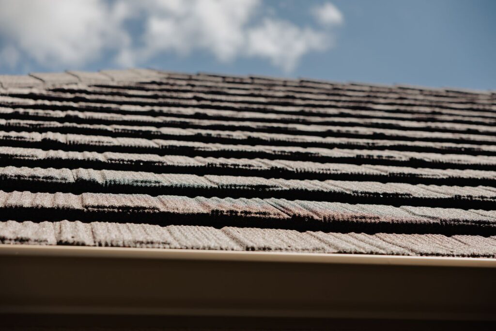 Close-up of asphalt shingle courses and the gutter line on a North Texas roof