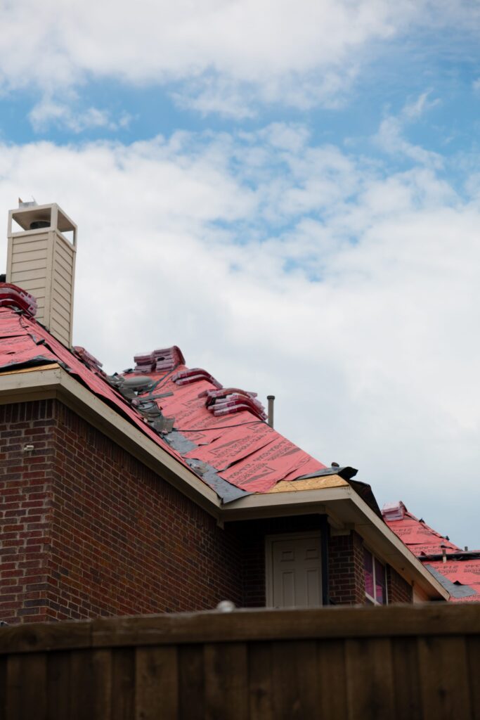 Roof replacement in progress, with underlayment down and shingle bundles staged on the slope