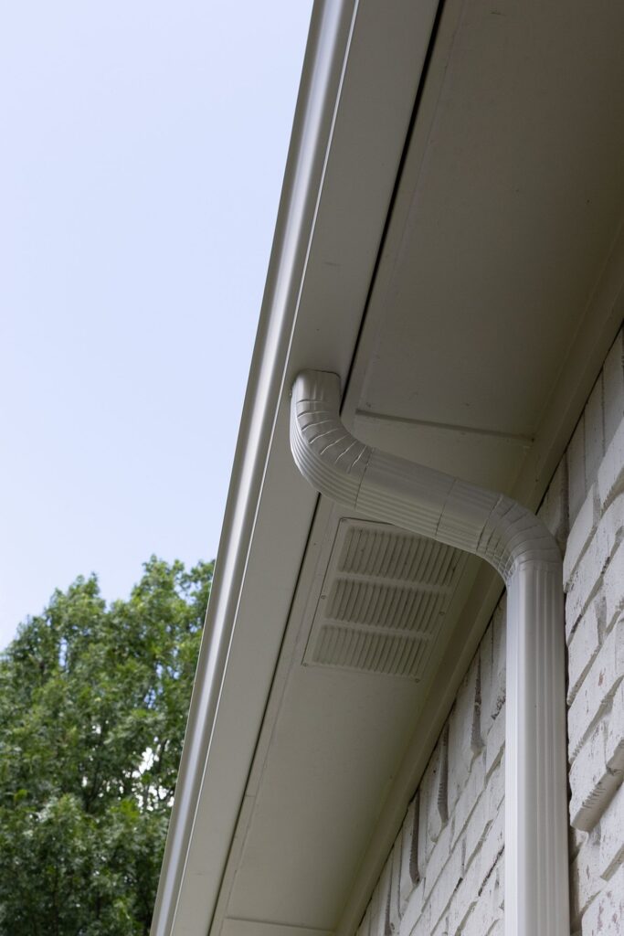 Close-up of a downspout against brick