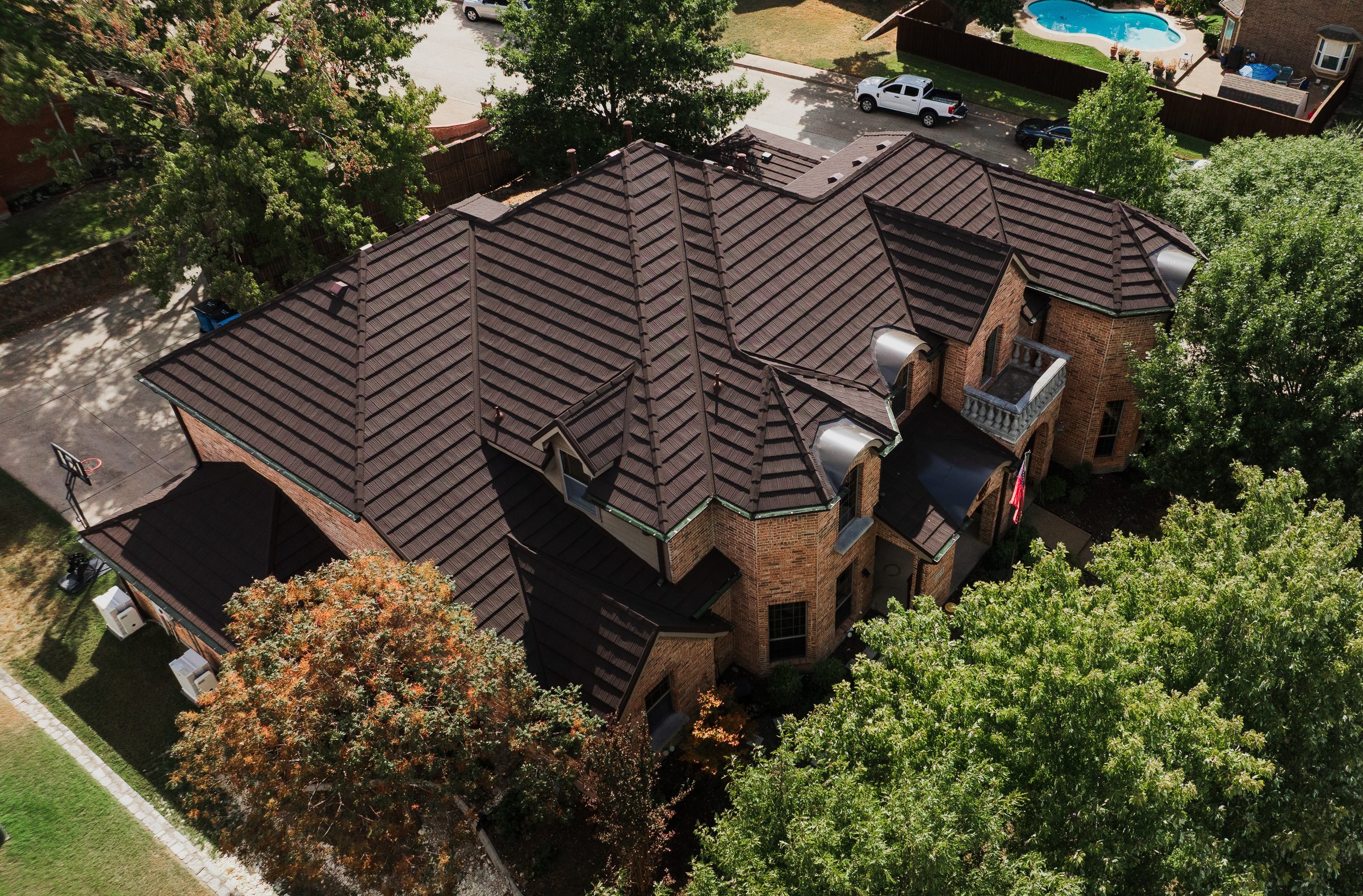 Aerial view of a completed brown roof on a brick home in North Texas